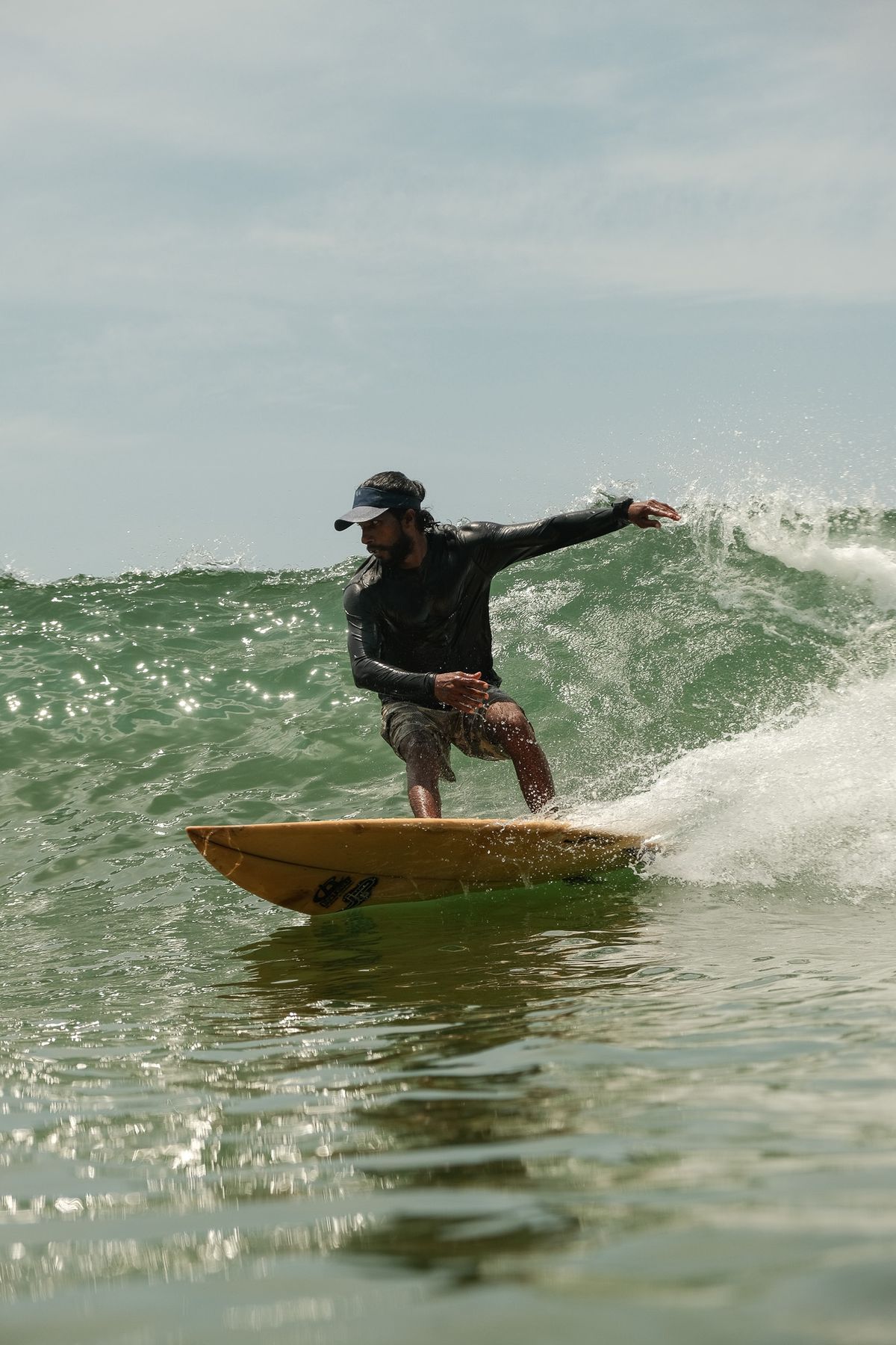 Surfer turning on a wave, spray flying, seen from the water
