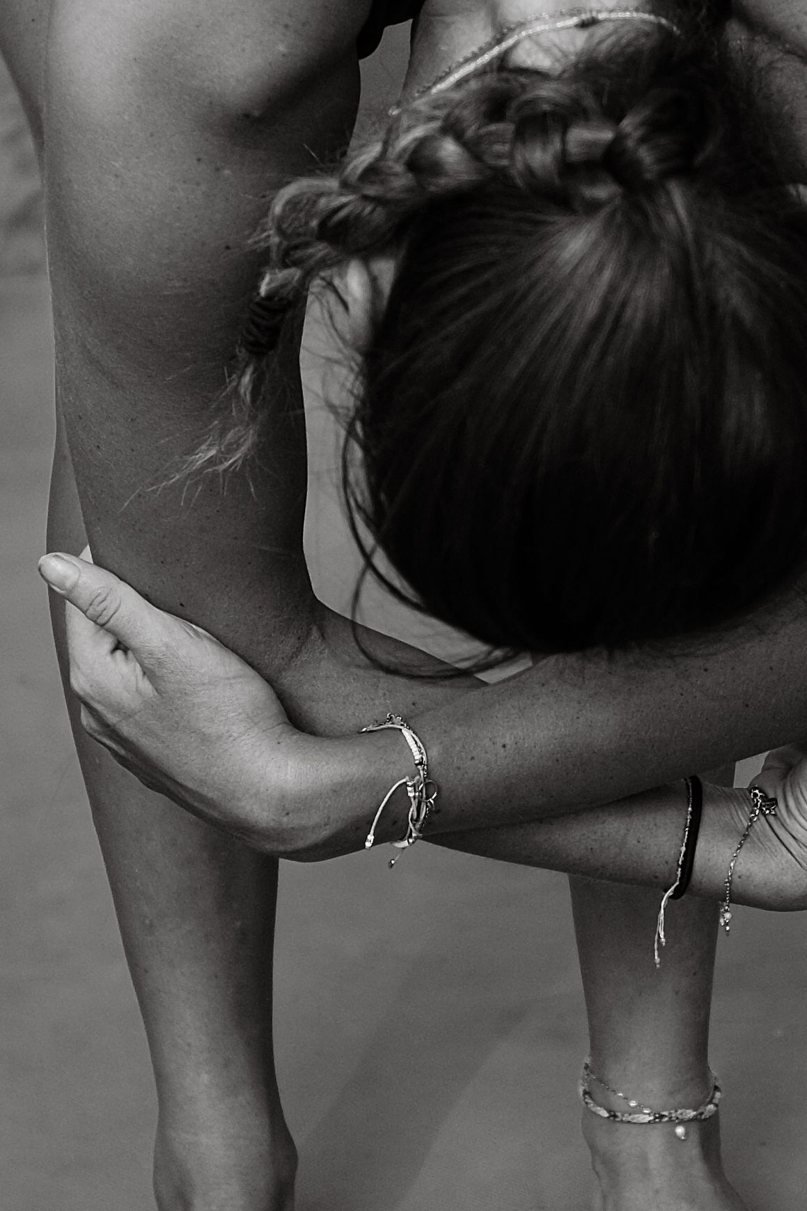 Black and white close-up of a woman stretching, arm across her body