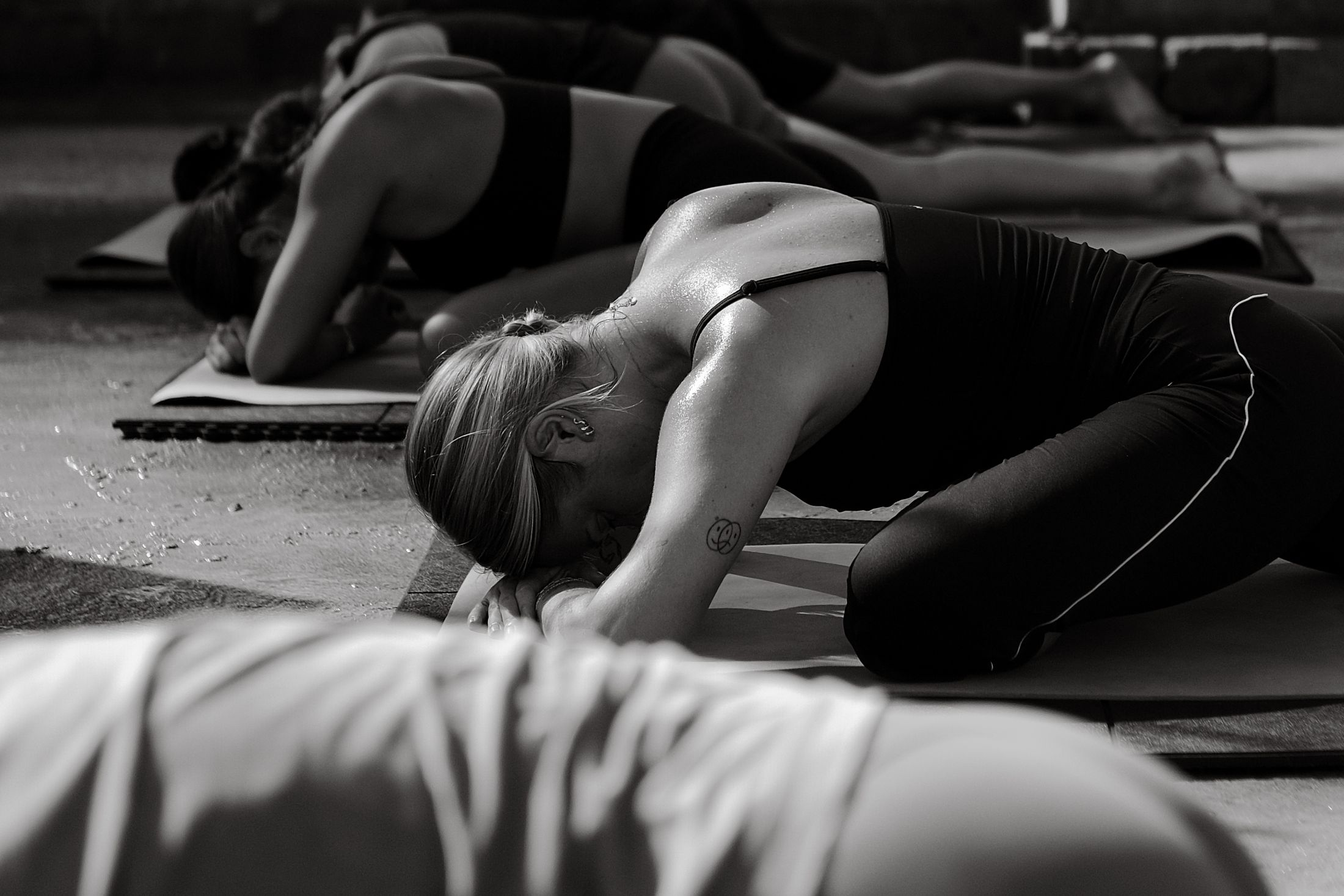 Black and white shot of a yoga class lying on their mats
